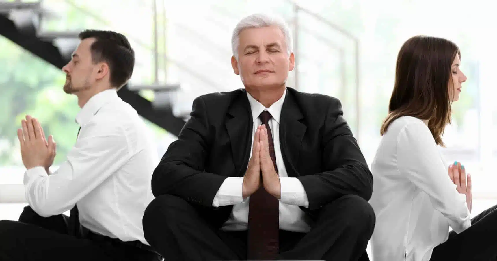 Führungskräfte im Business-Outfit sitzen meditierend im Büro – Symbol für mentale Stärke, Fokus und Stressresilienz mit Smiling Wisdom