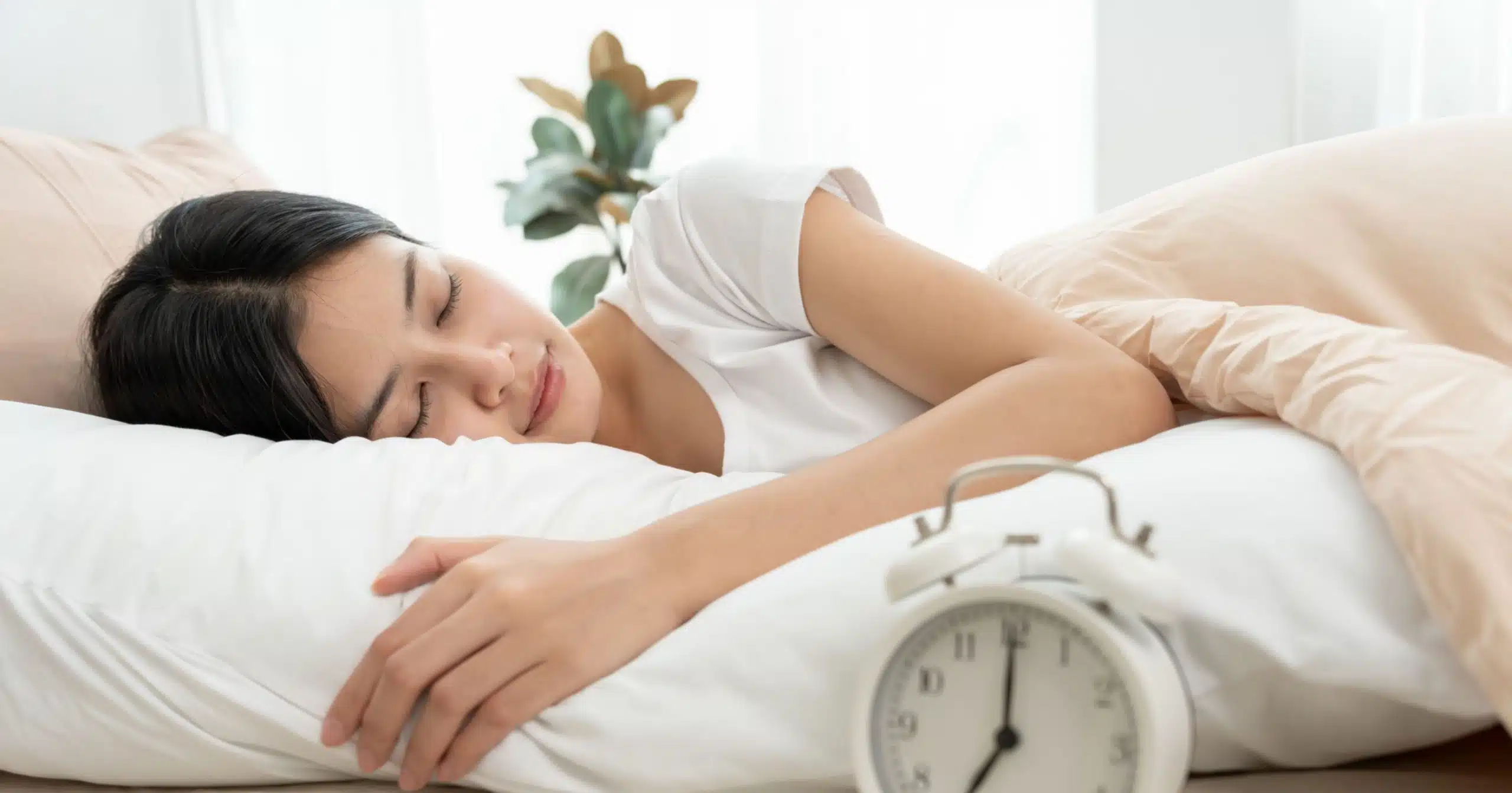 Entspannter schlafender Mann auf weißem Kissen – Symbol für tiefe Regeneration und erholsamen Schlaf mit Smiling Wisdom